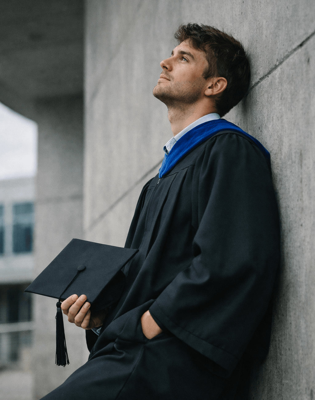 Male Graduate Reflecting With Cap in Hand